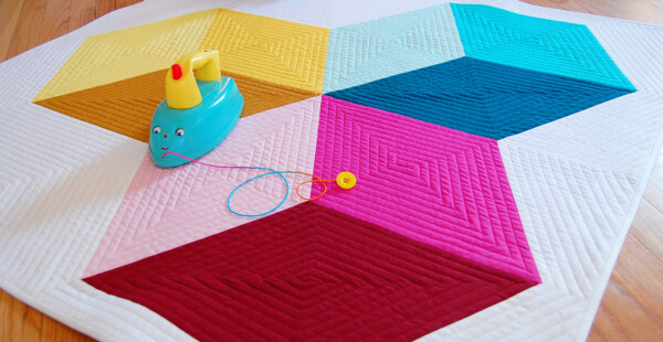 Yellow, Pink and blue dimensional block baby quilt with toy iron.